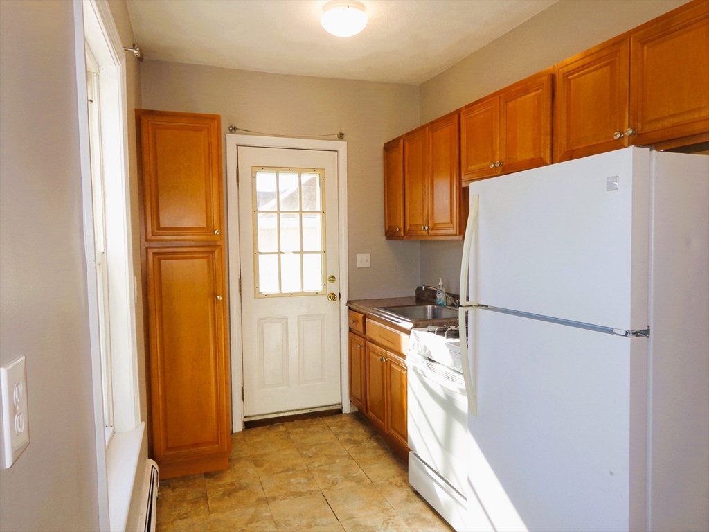 a kitchen with a refrigerator a stove top oven and cabinets