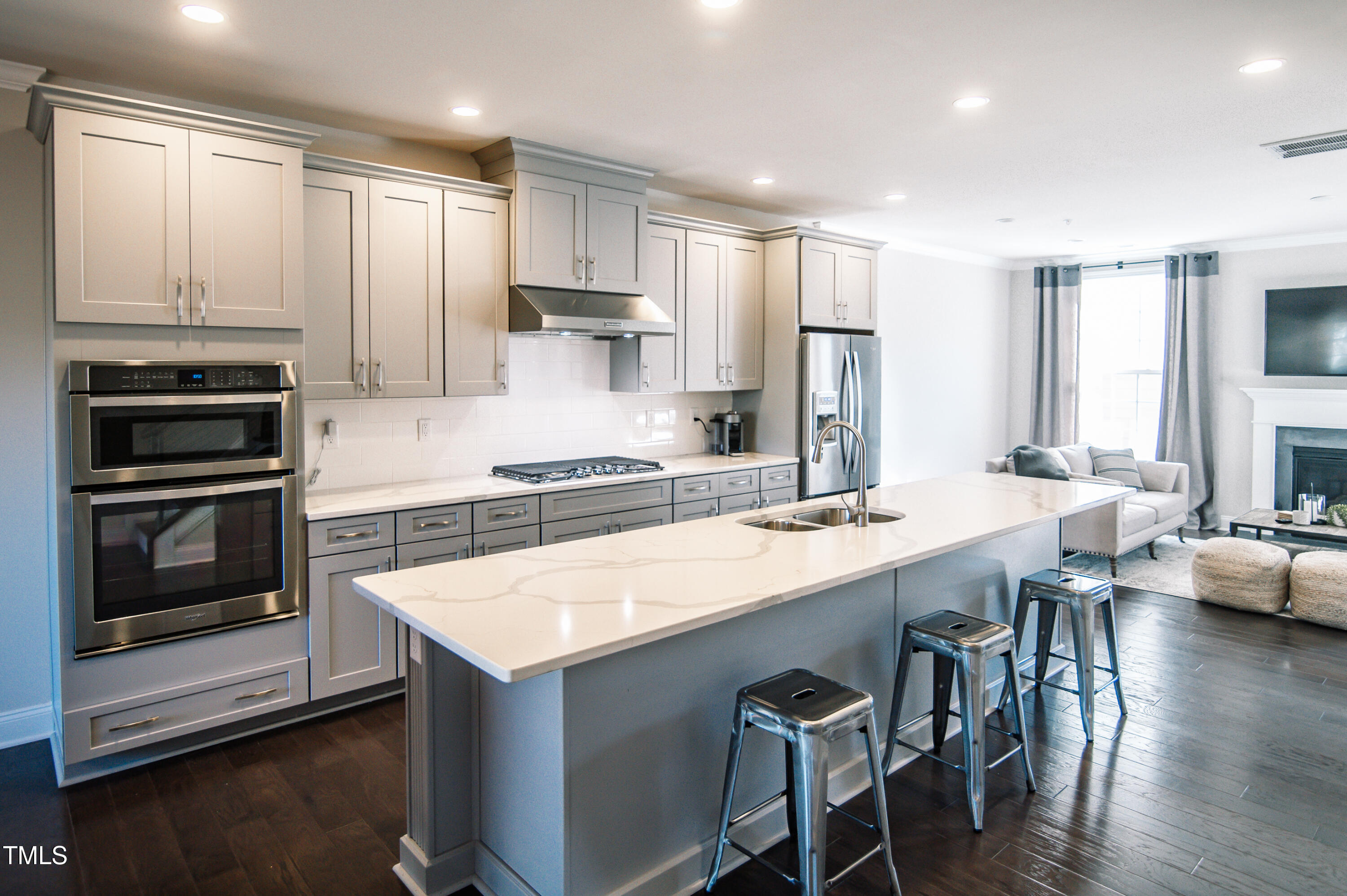 an open kitchen with granite countertop a stove and white cabinets