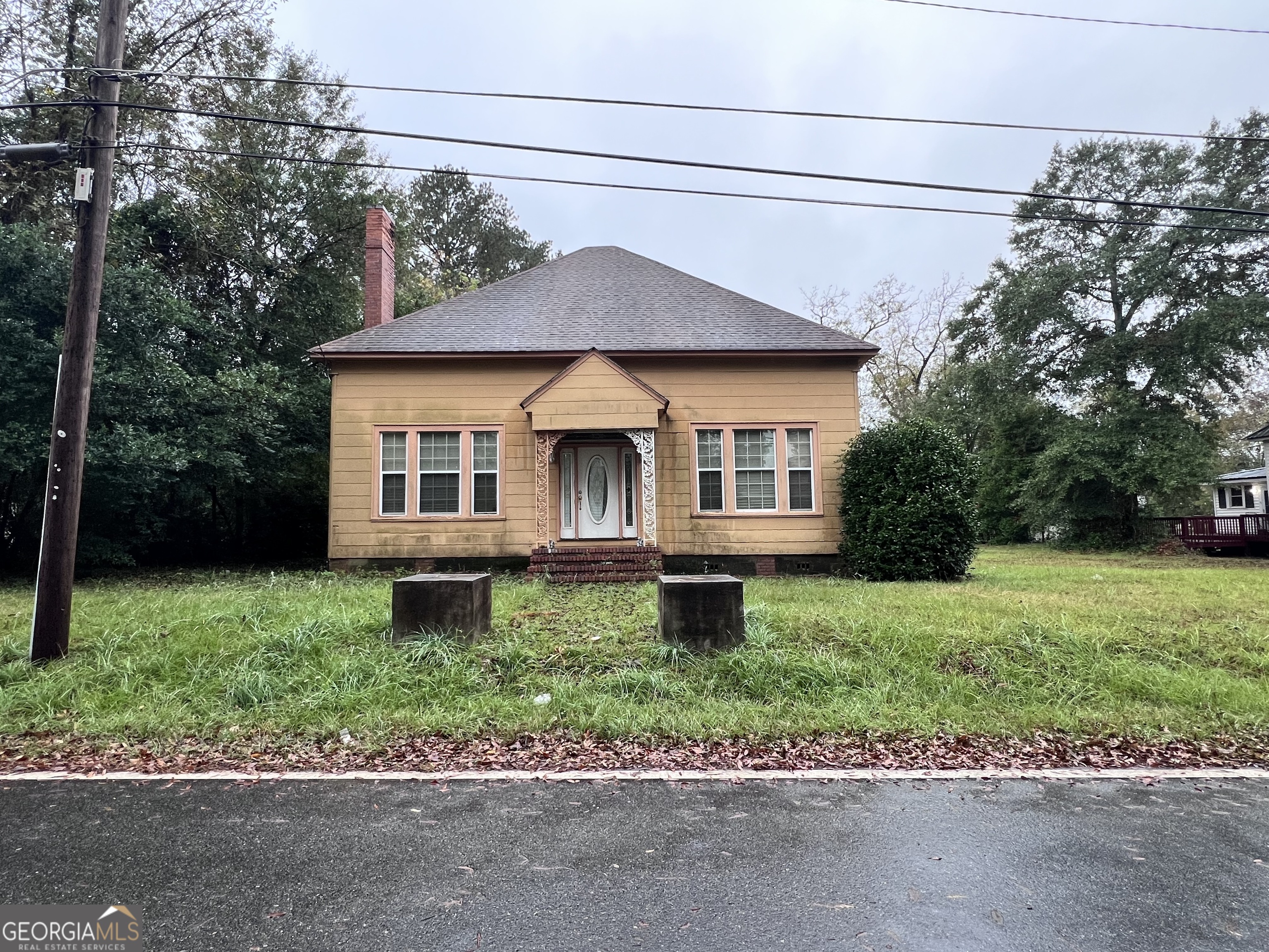 a front view of a house with a garden and yard