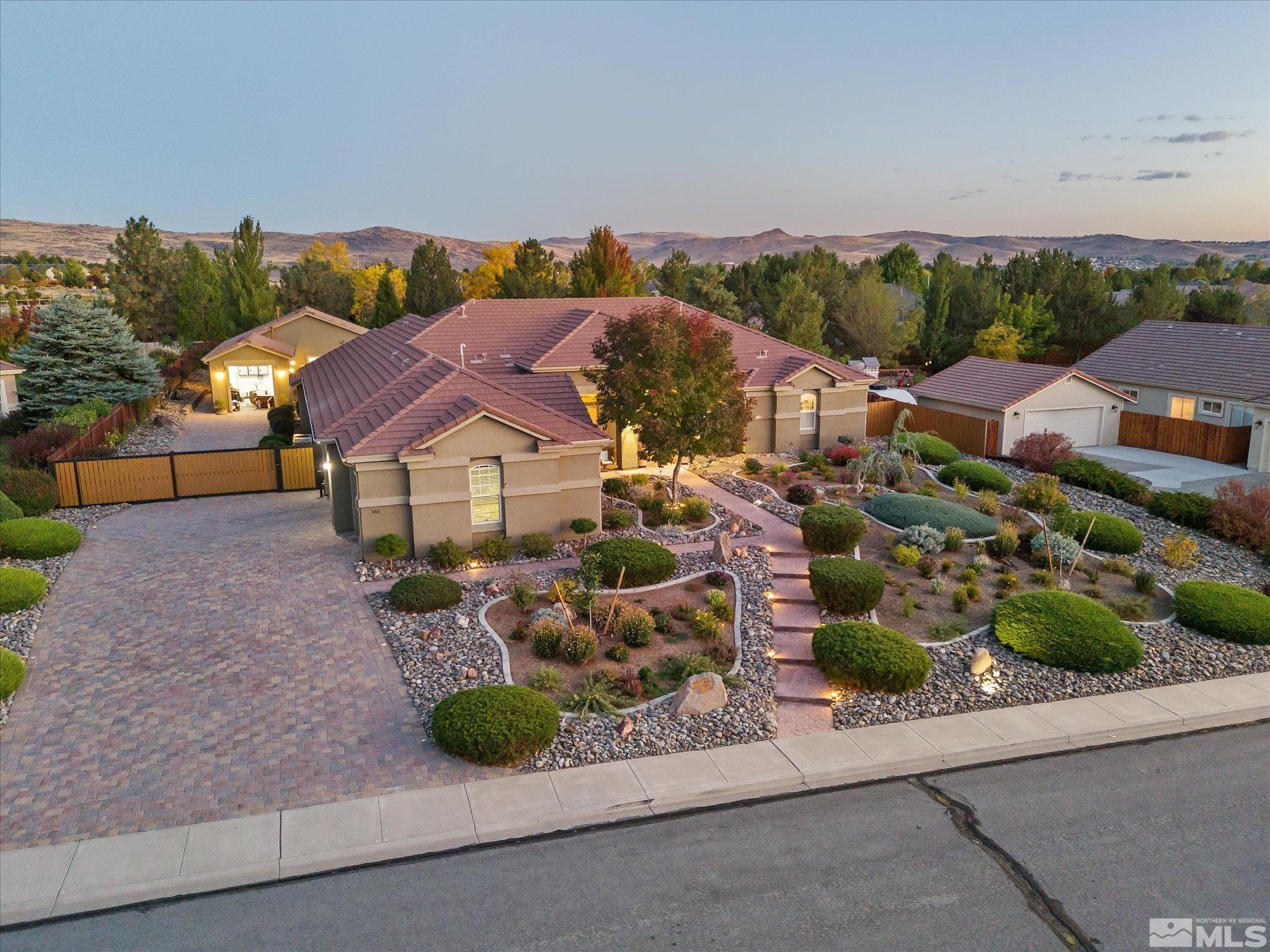 an aerial view of a house with a garden and mountain view in back