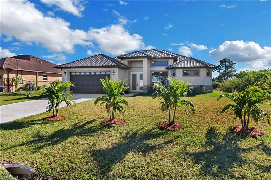 View of front of home with a garage and a front lawn