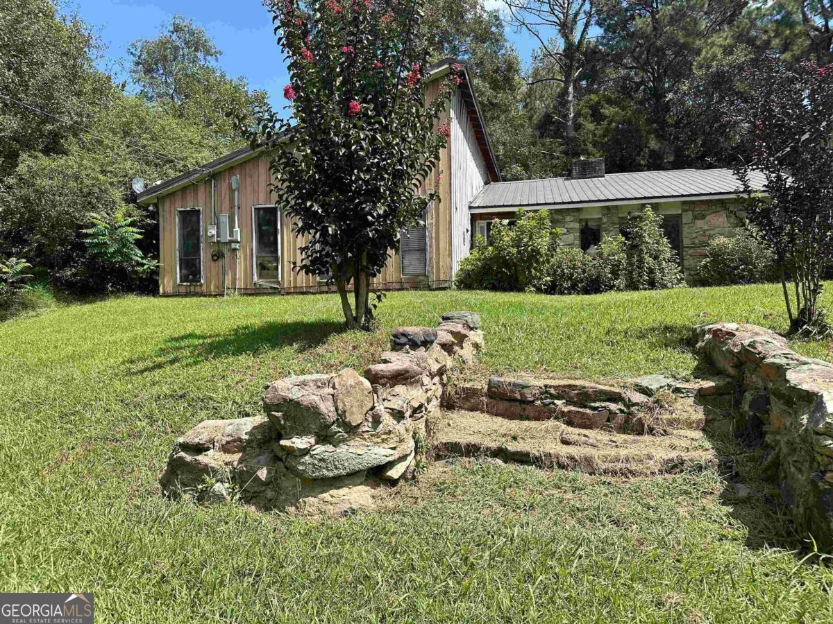 a view of backyard of house with outdoor seating and green space