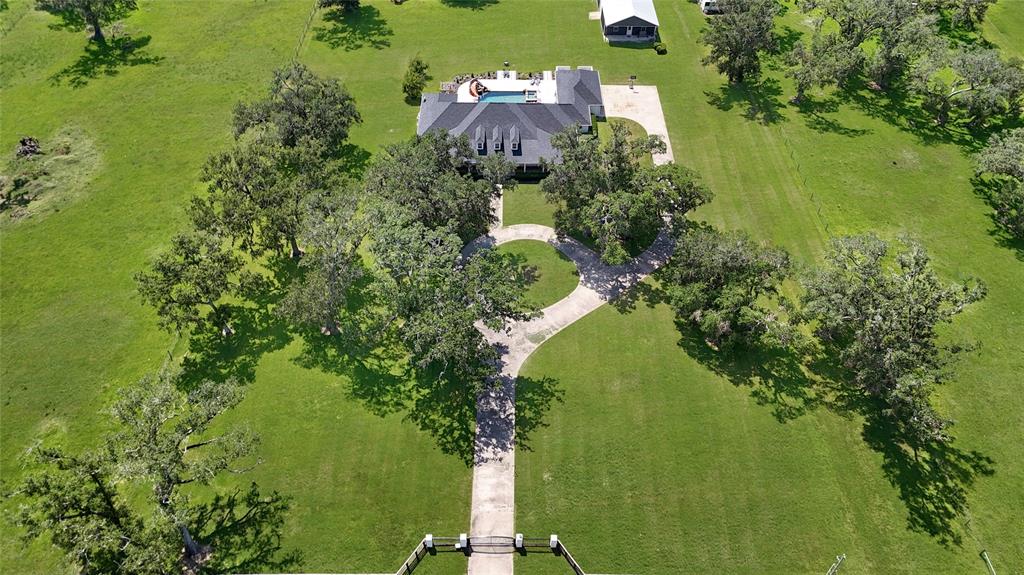 an aerial view of a house with a yard lake lake view and trees around