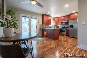 a kitchen with stainless steel appliances a dining table chairs and refrigerator