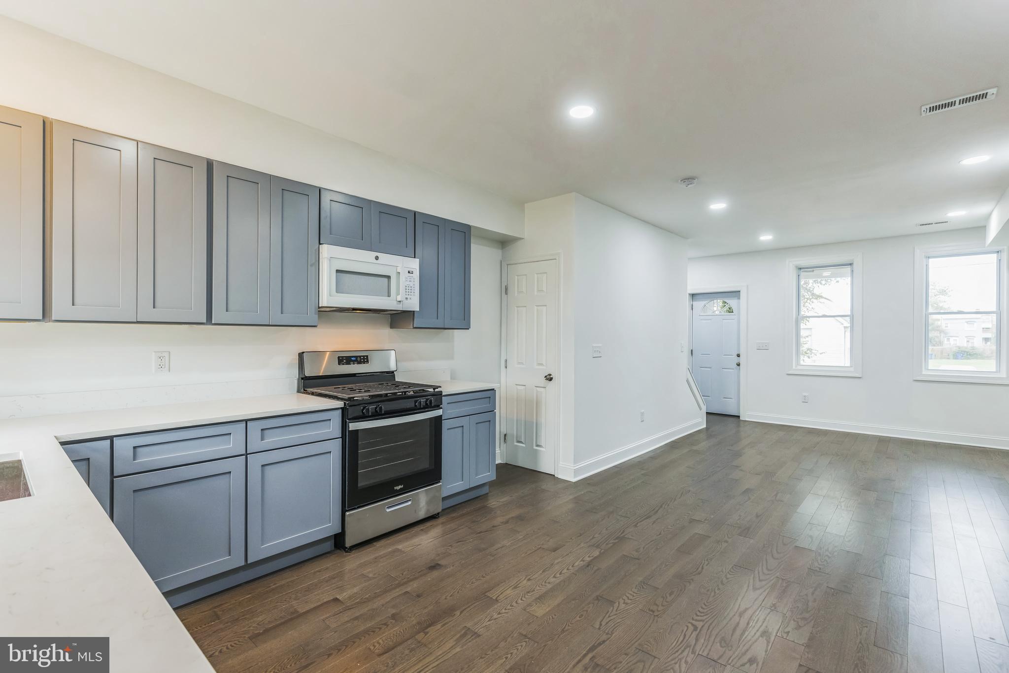 a kitchen with a sink and wooden floor