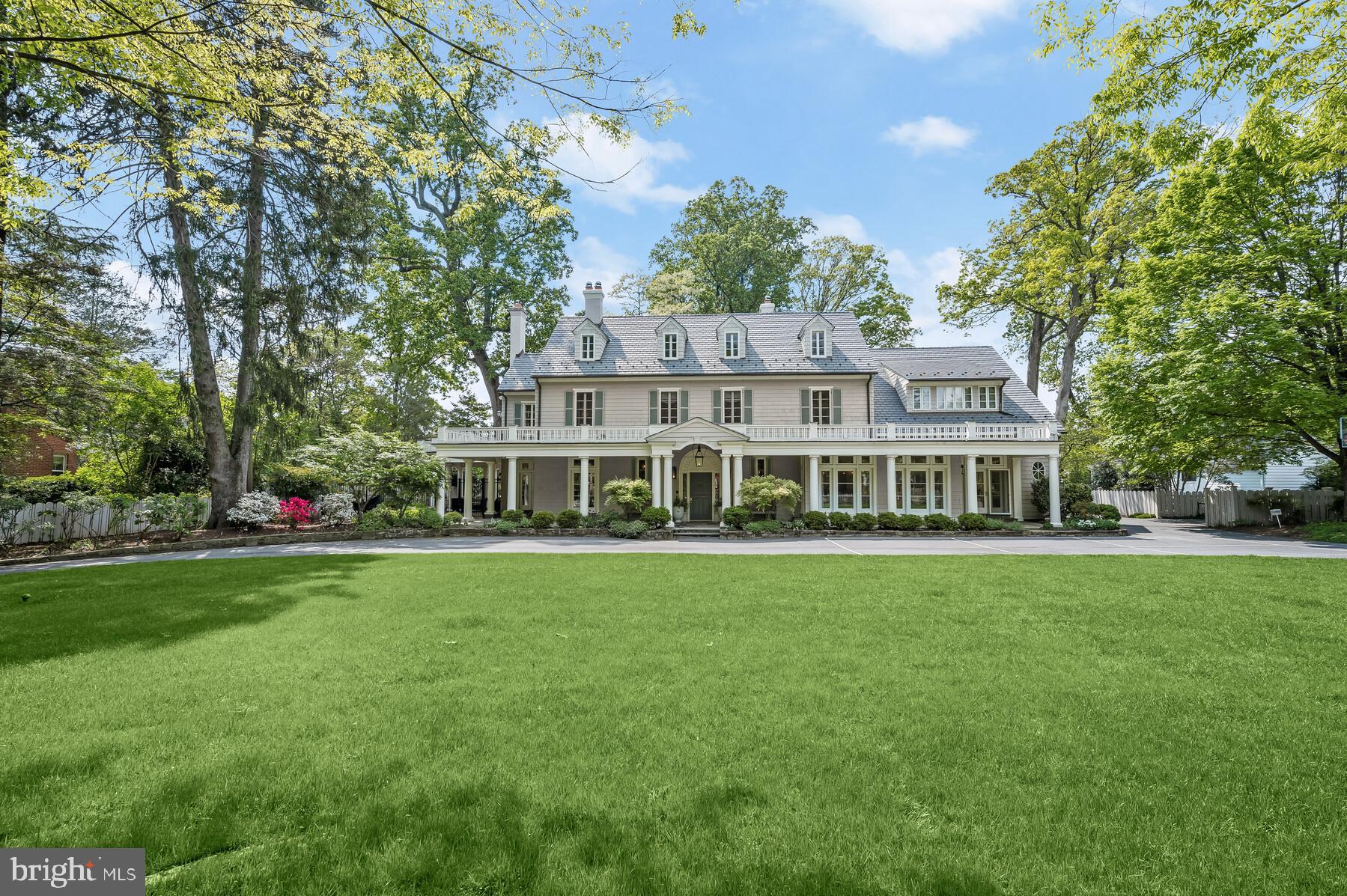 a view of a house with a big yard and large trees