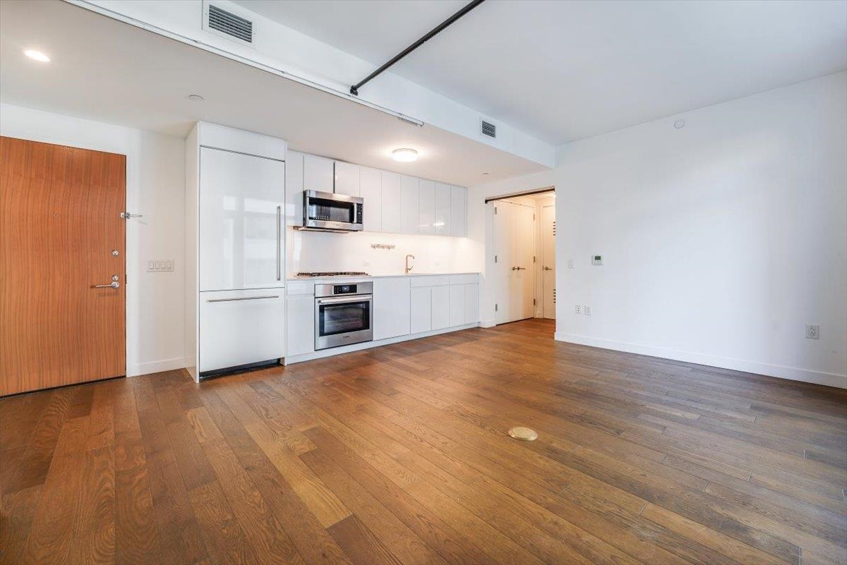 a view of a kitchen with a sink stove cabinets and empty room