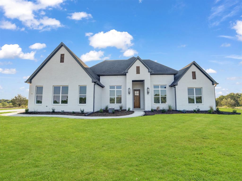 a front view of a house with a garden and yard