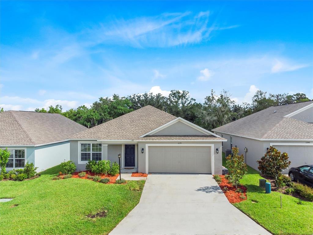 a front view of a house with a yard and garage