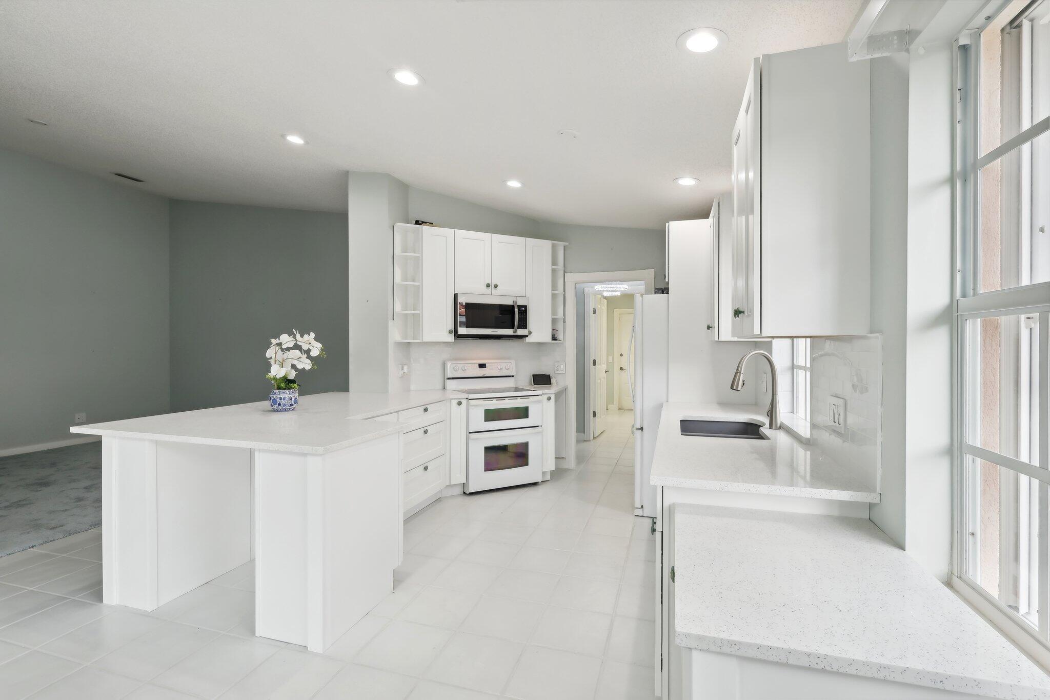 a kitchen with white cabinets and refrigerator