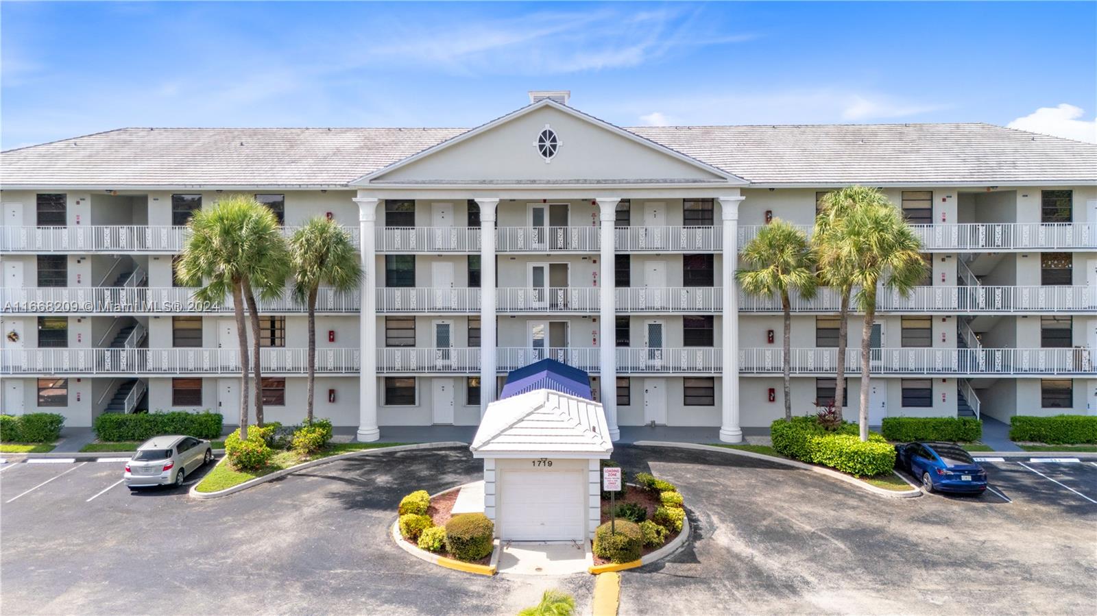 a front view of a residential apartment building with a yard