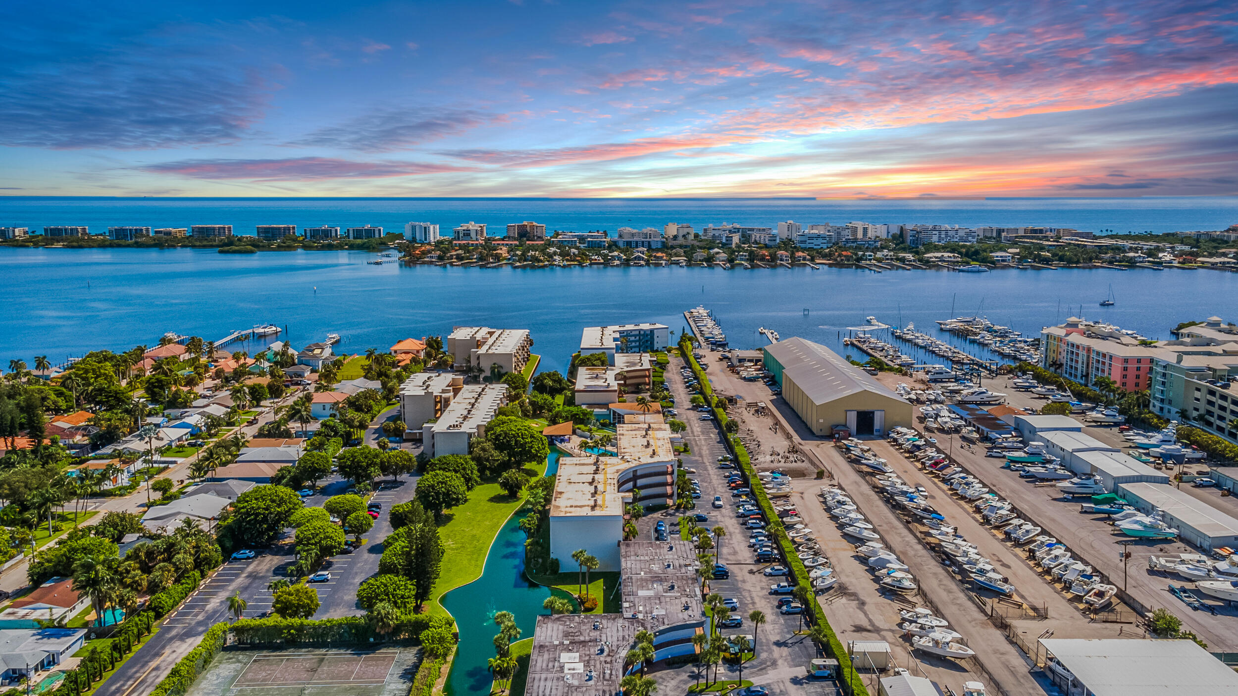 an aerial view of a city with lots of residential buildings ocean and mountain view in back