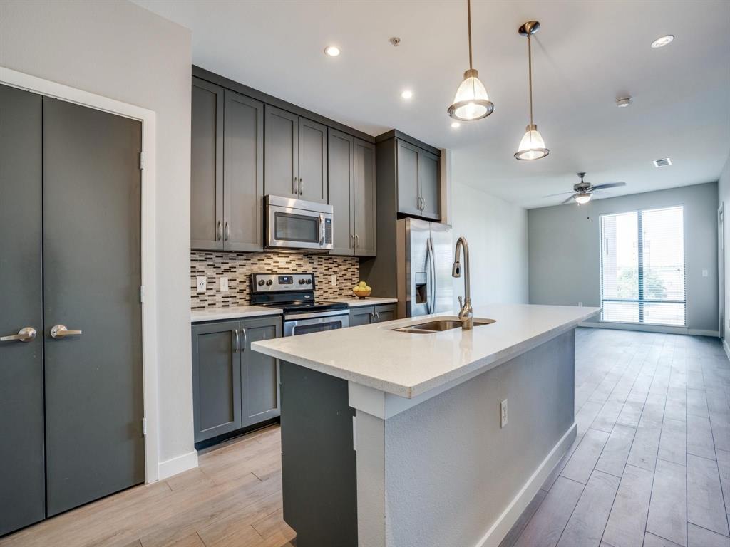 a kitchen with kitchen island a sink appliances and cabinets