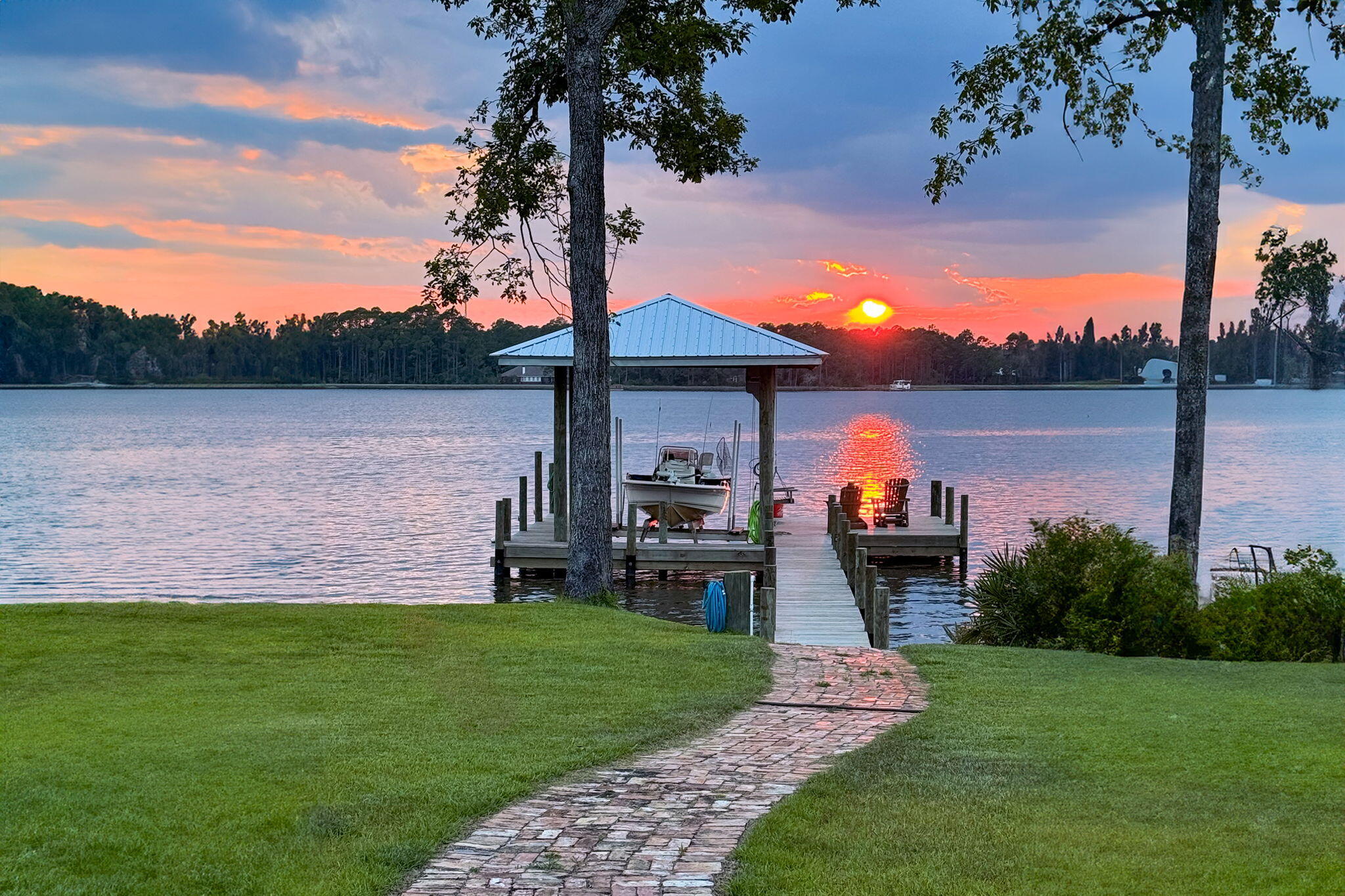 a front view of a house with a yard and lake view