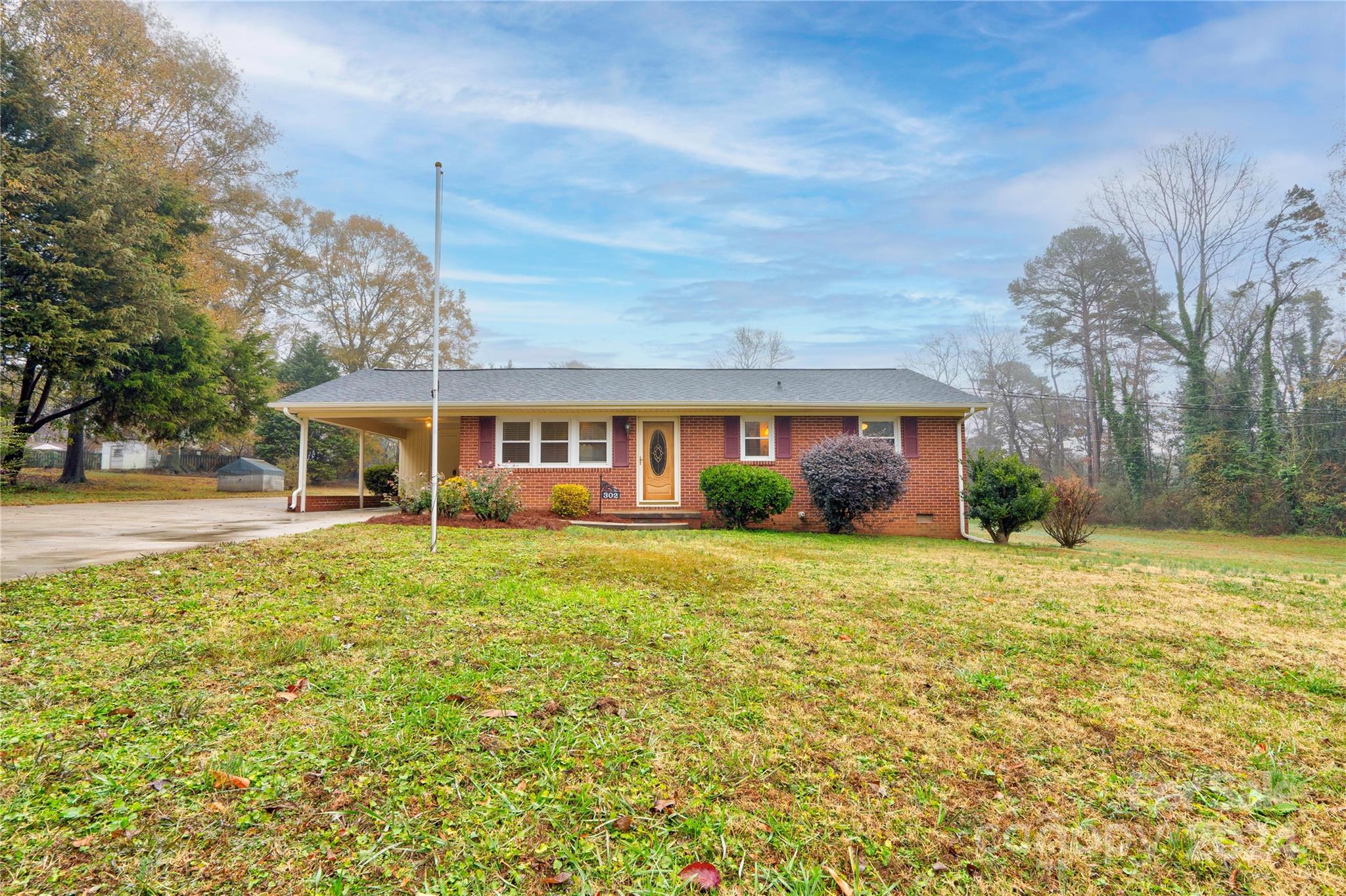 a front view of house with yard and trees in the background