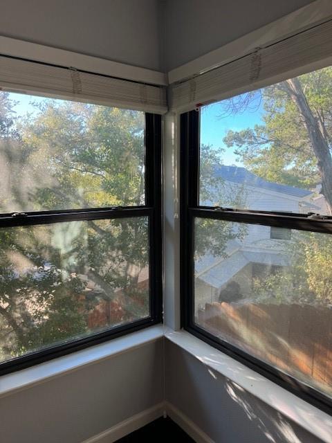 a view of a room with a large window and wooden floor