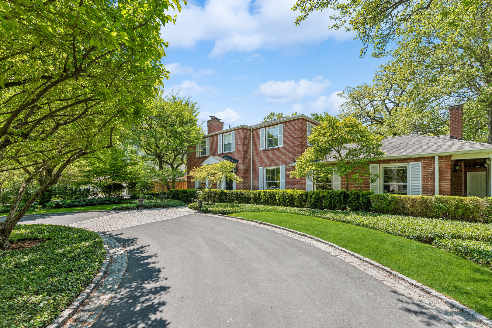 a view of a house with a big yard and large trees