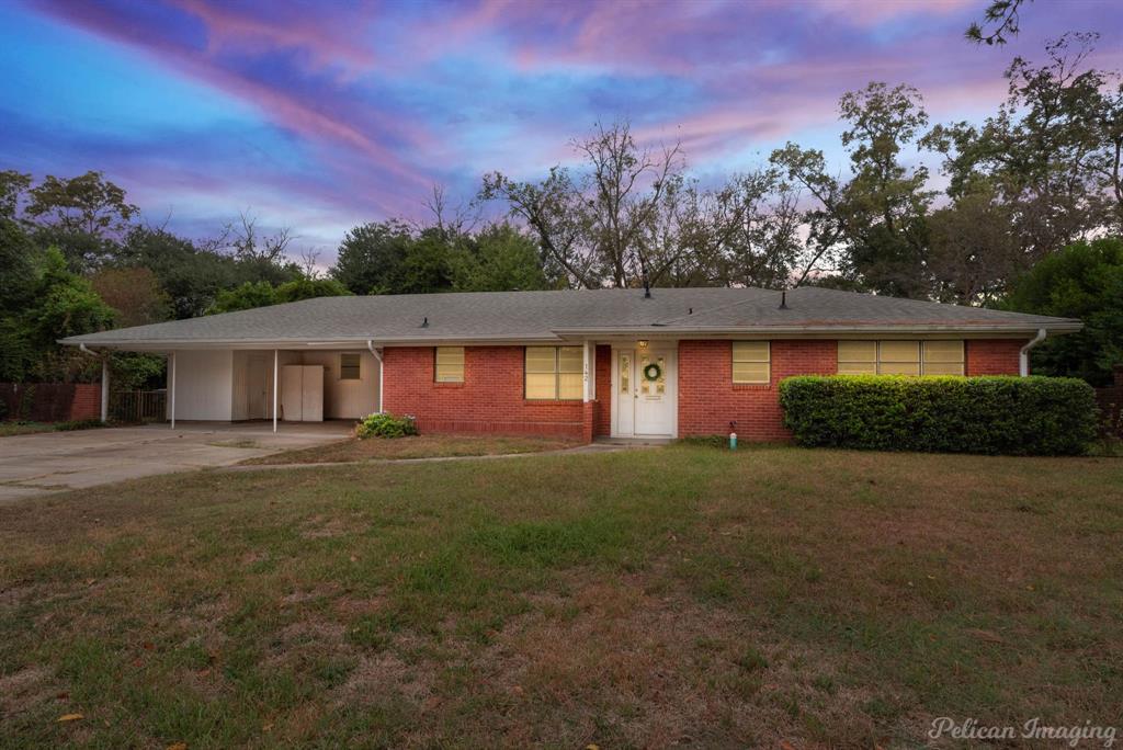 a front view of a house with a yard and trees