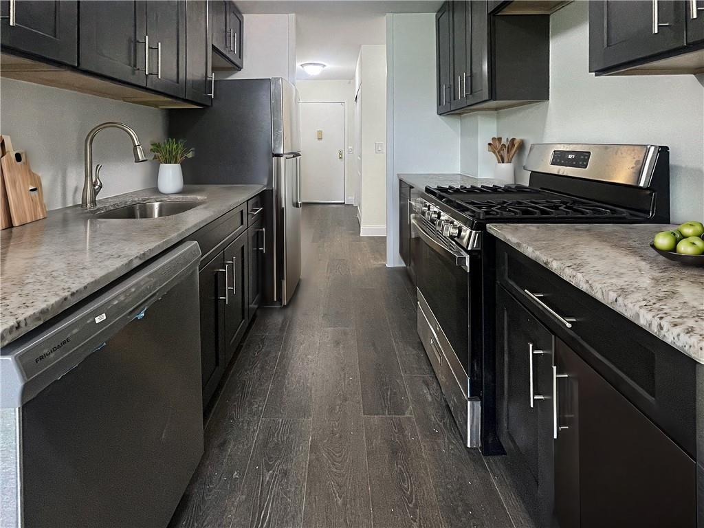 a kitchen with stainless steel appliances granite countertop a sink stove and refrigerator