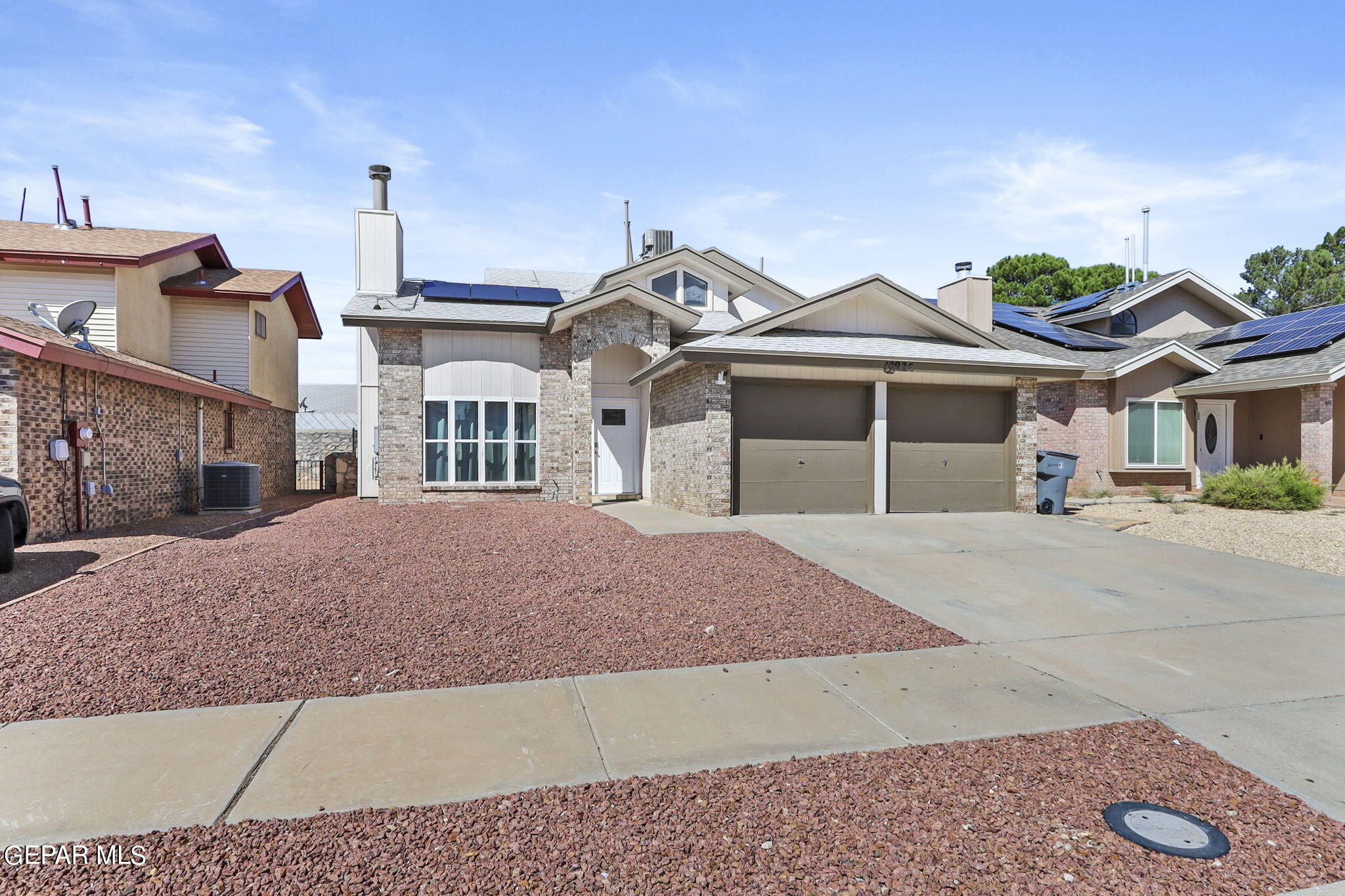 a front view of a house with a garden and garage