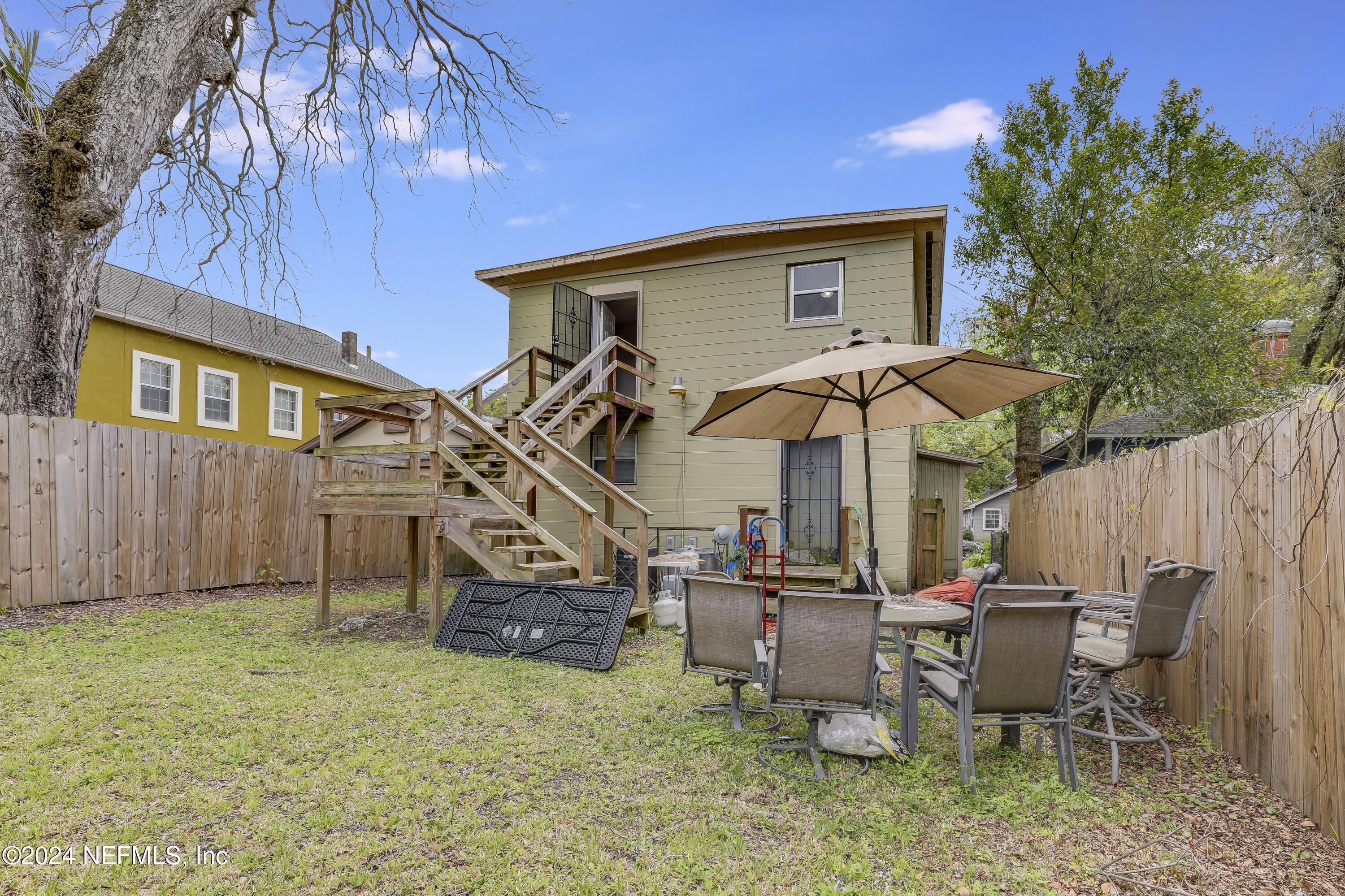 a view of a patio with table and chairs with wooden fence and plants