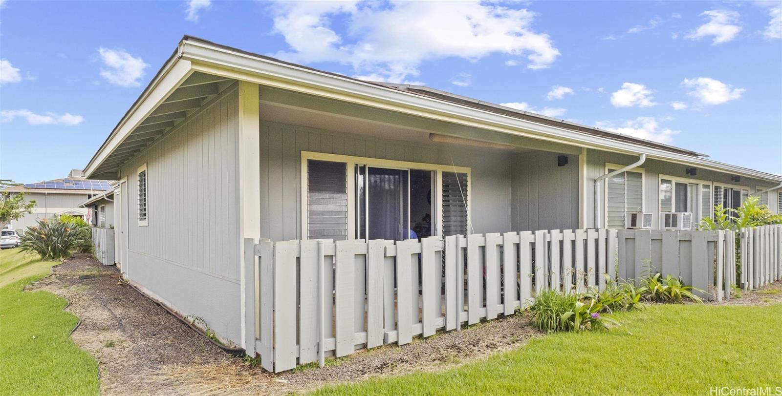 a view of a house with a small yard and wooden fence