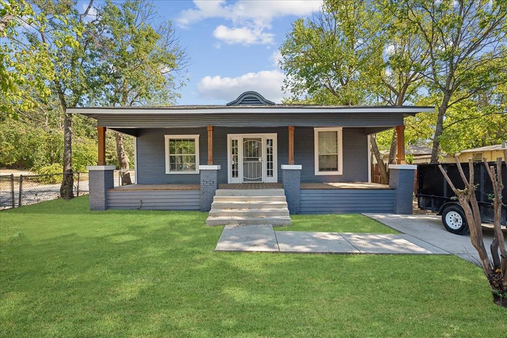 a view of a house with backyard and a tree