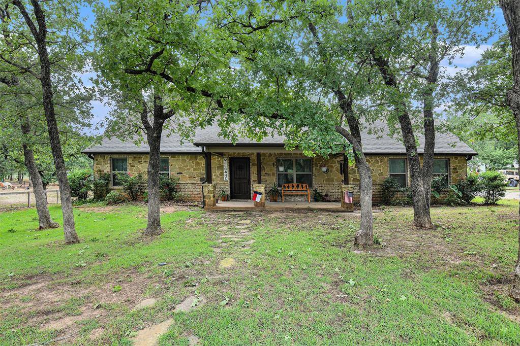 a view of a house with backyard and a tree