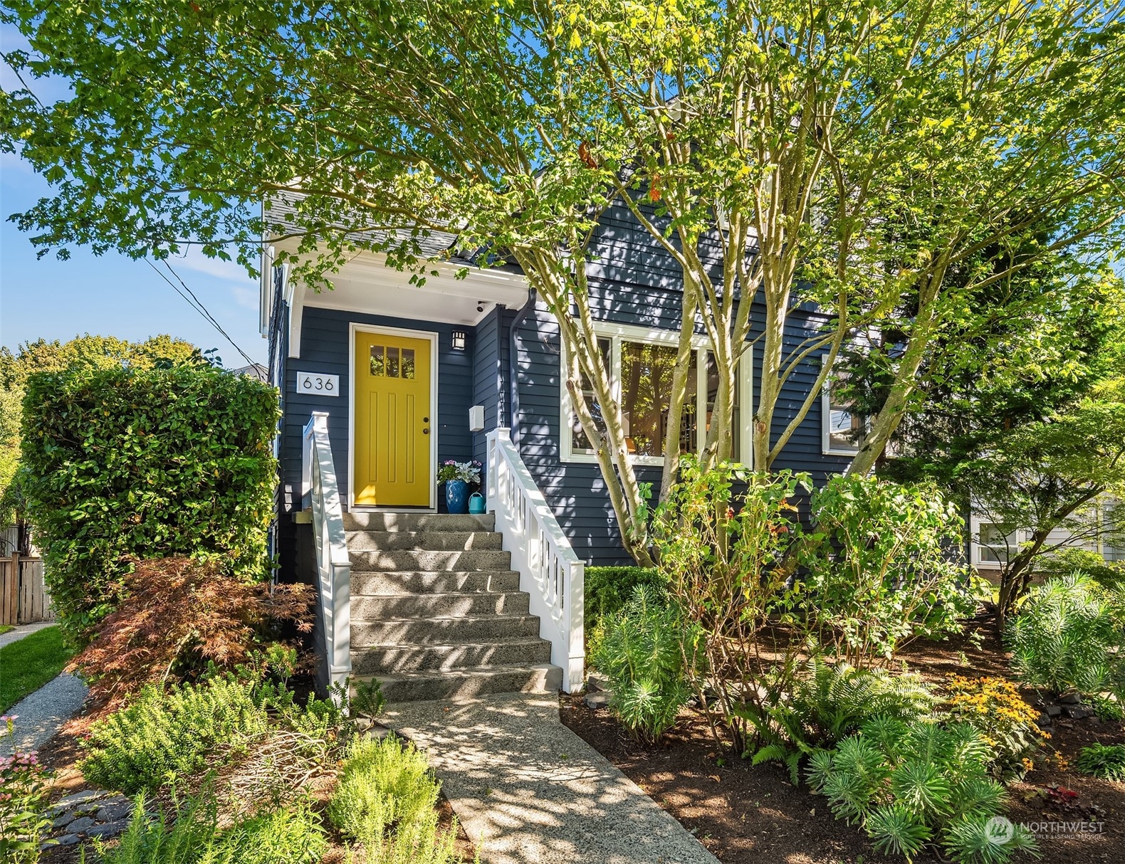 a front view of a house with a tree