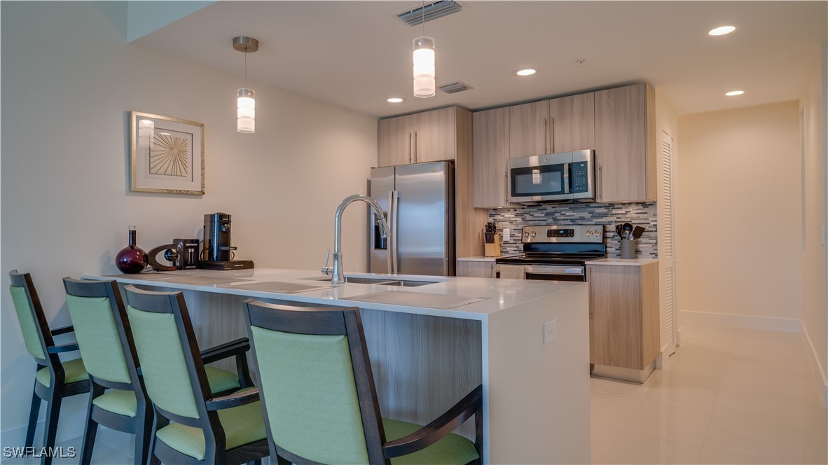 a kitchen with stainless steel appliances a refrigerator and a stove top oven