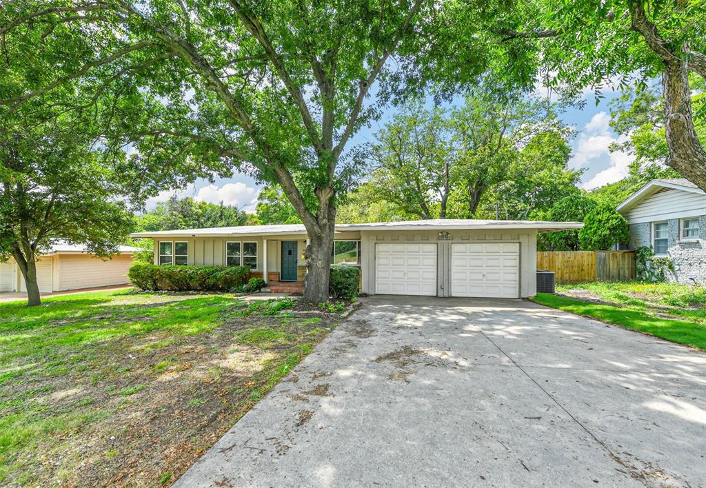 a front view of a house with a yard and trees