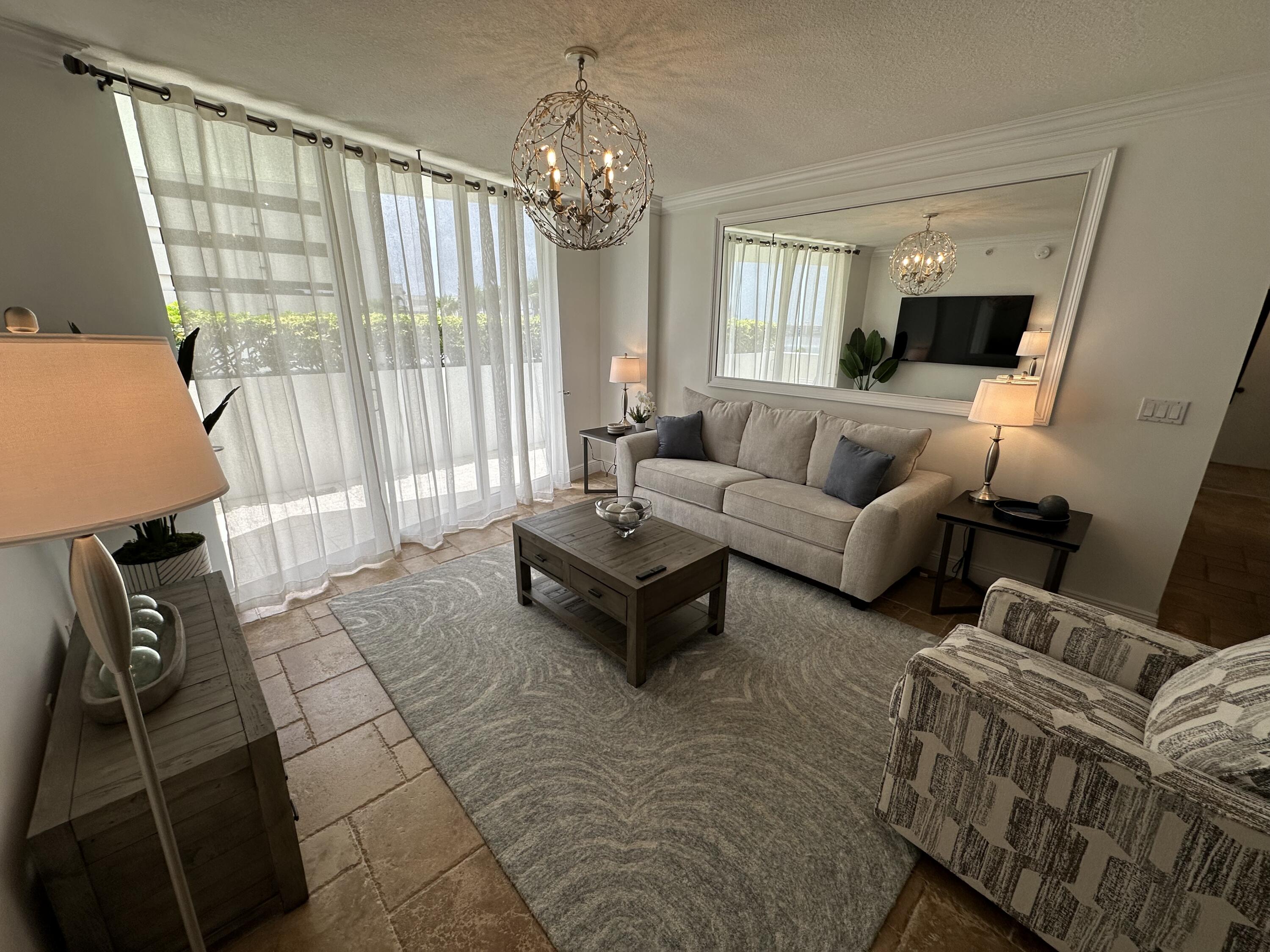 a living room with furniture and a chandelier