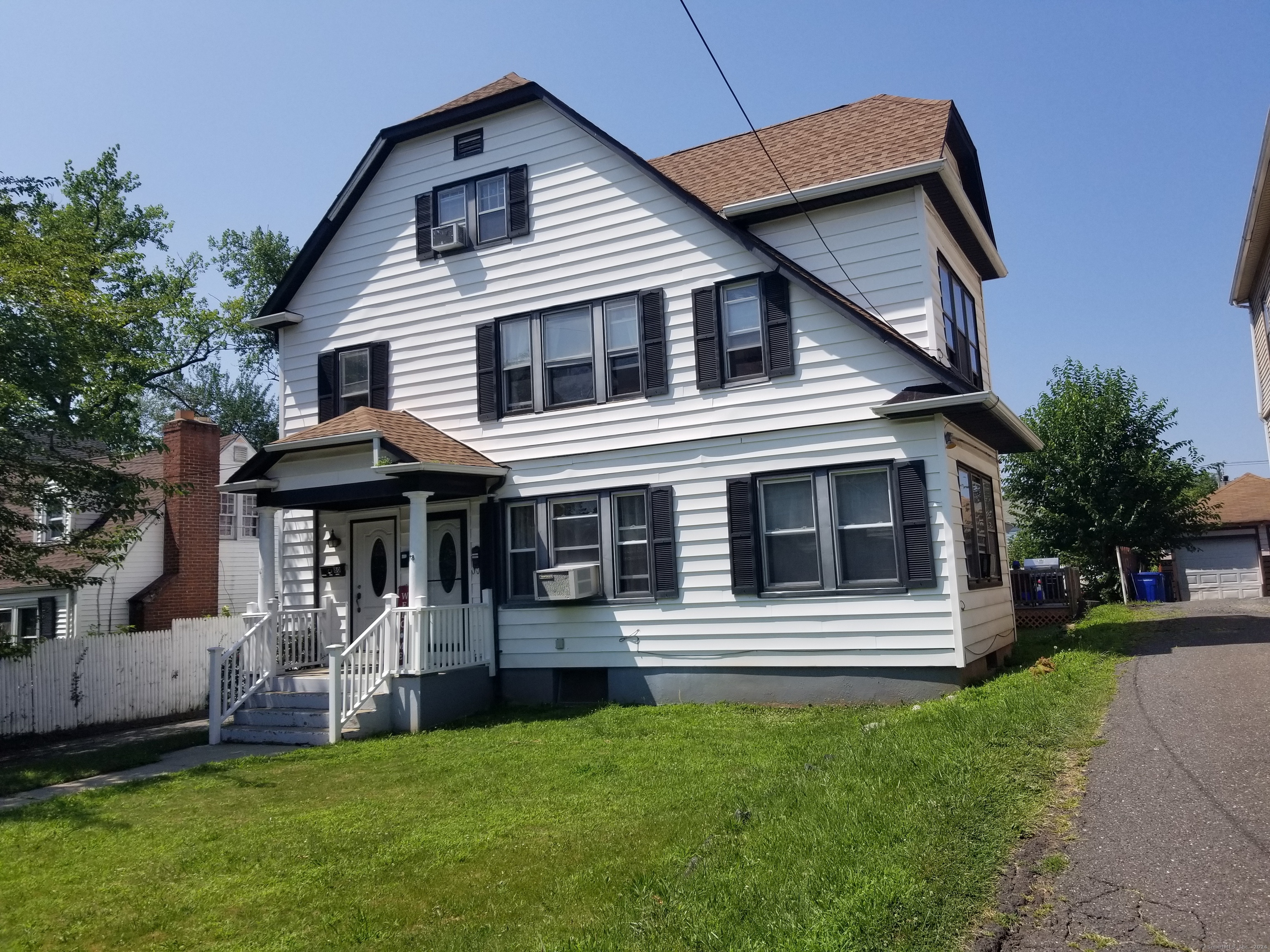 a view of a house with a yard and stairs