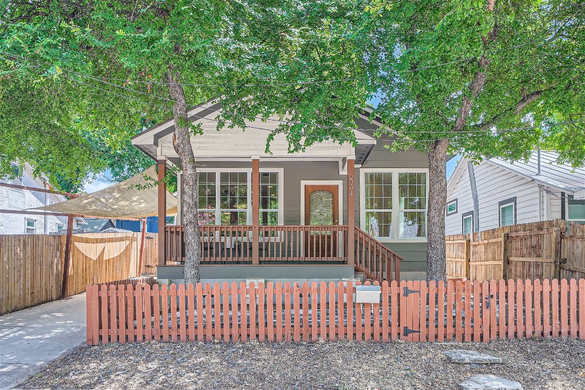 a view of a house with a small yard and wooden fence