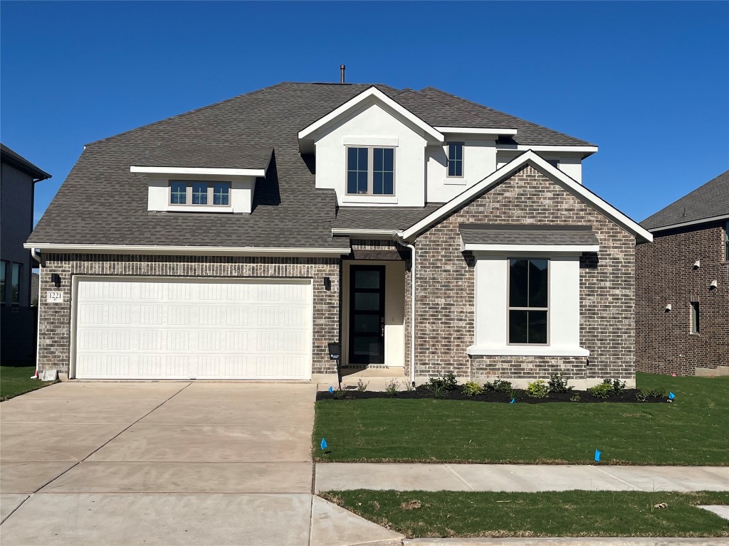 a front view of a house with a yard and garage