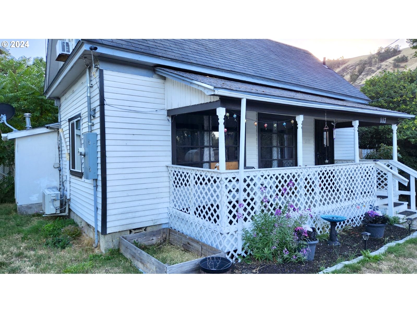 a view of a house with a small yard and wooden fence