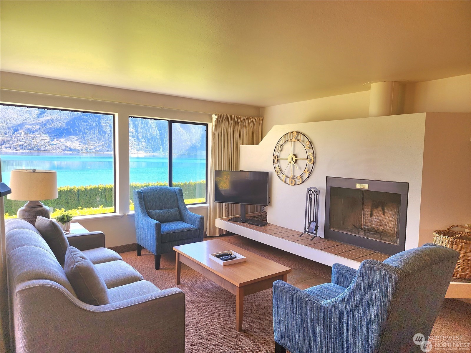 a living room with furniture a clock and a large window