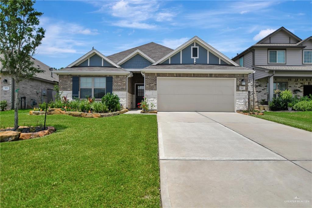 View of front facade featuring a garage and a front yard