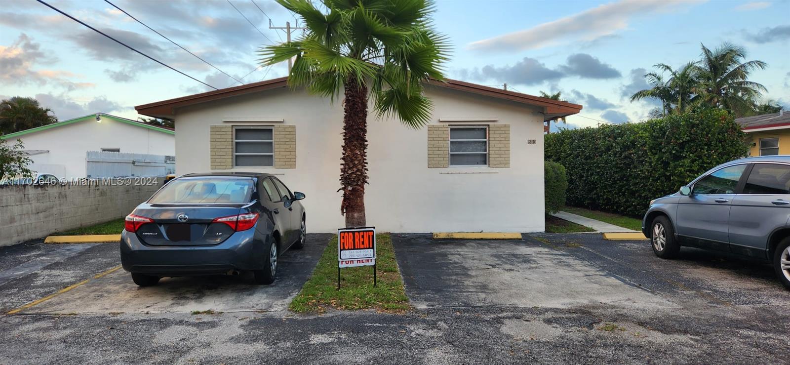 a front view of a house with a garden and parking space