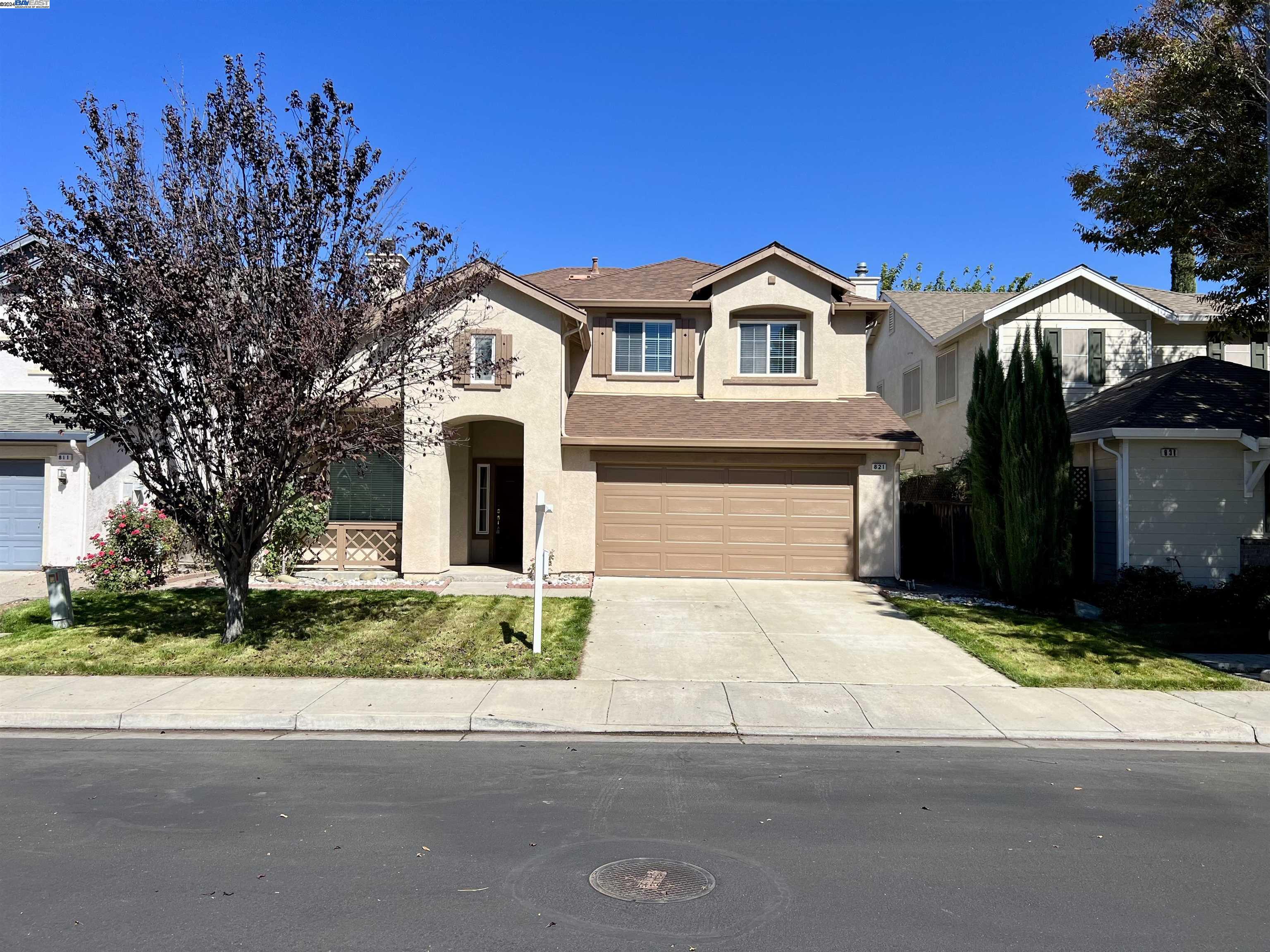 a front view of a house with yard and parking