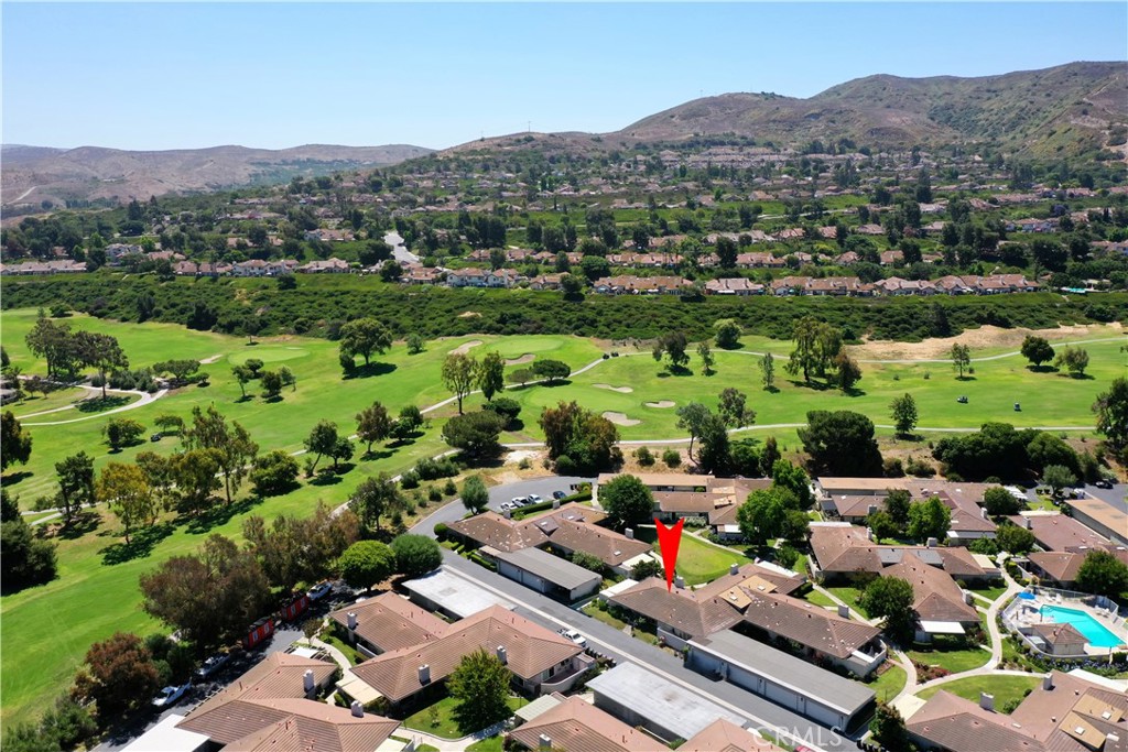 an aerial view of a houses with a lush green hillside