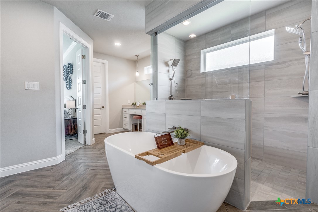 a white bath tub sitting in a bathroom and mirror