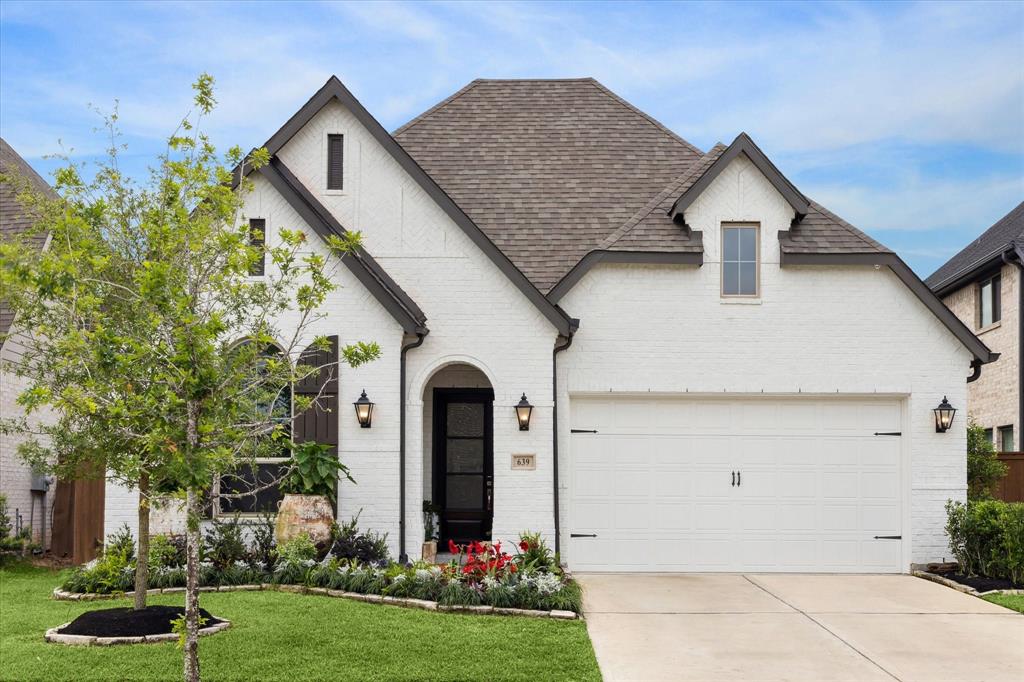 a front view of a house with a yard and garage