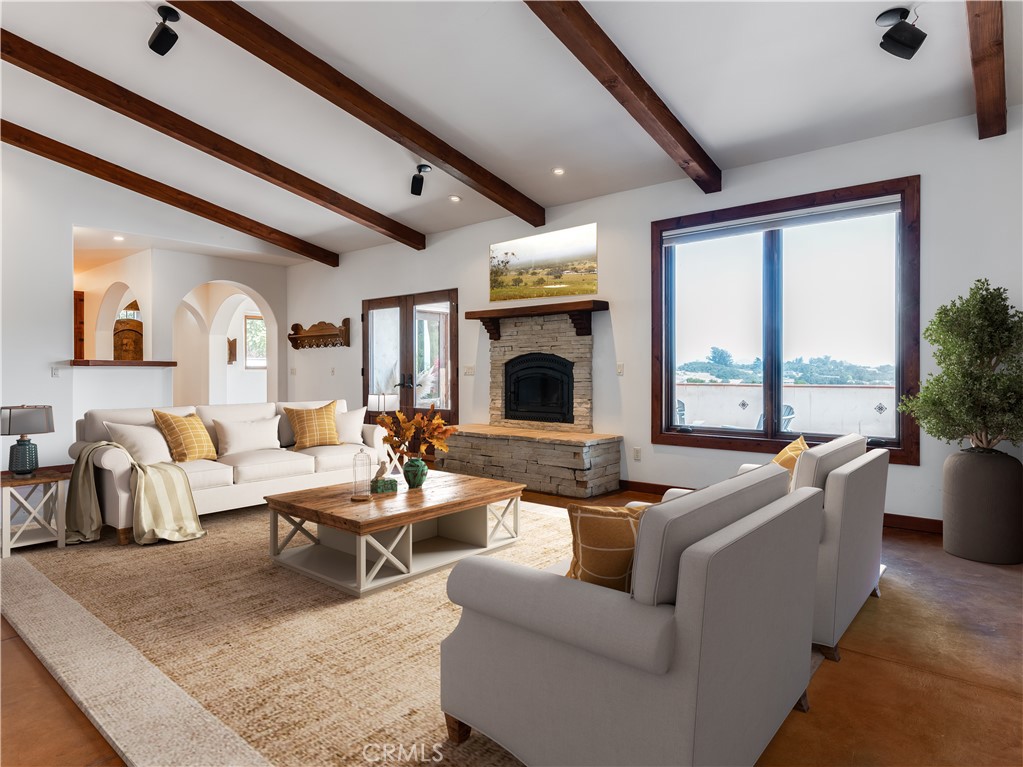 a living room with fireplace furniture and a large window