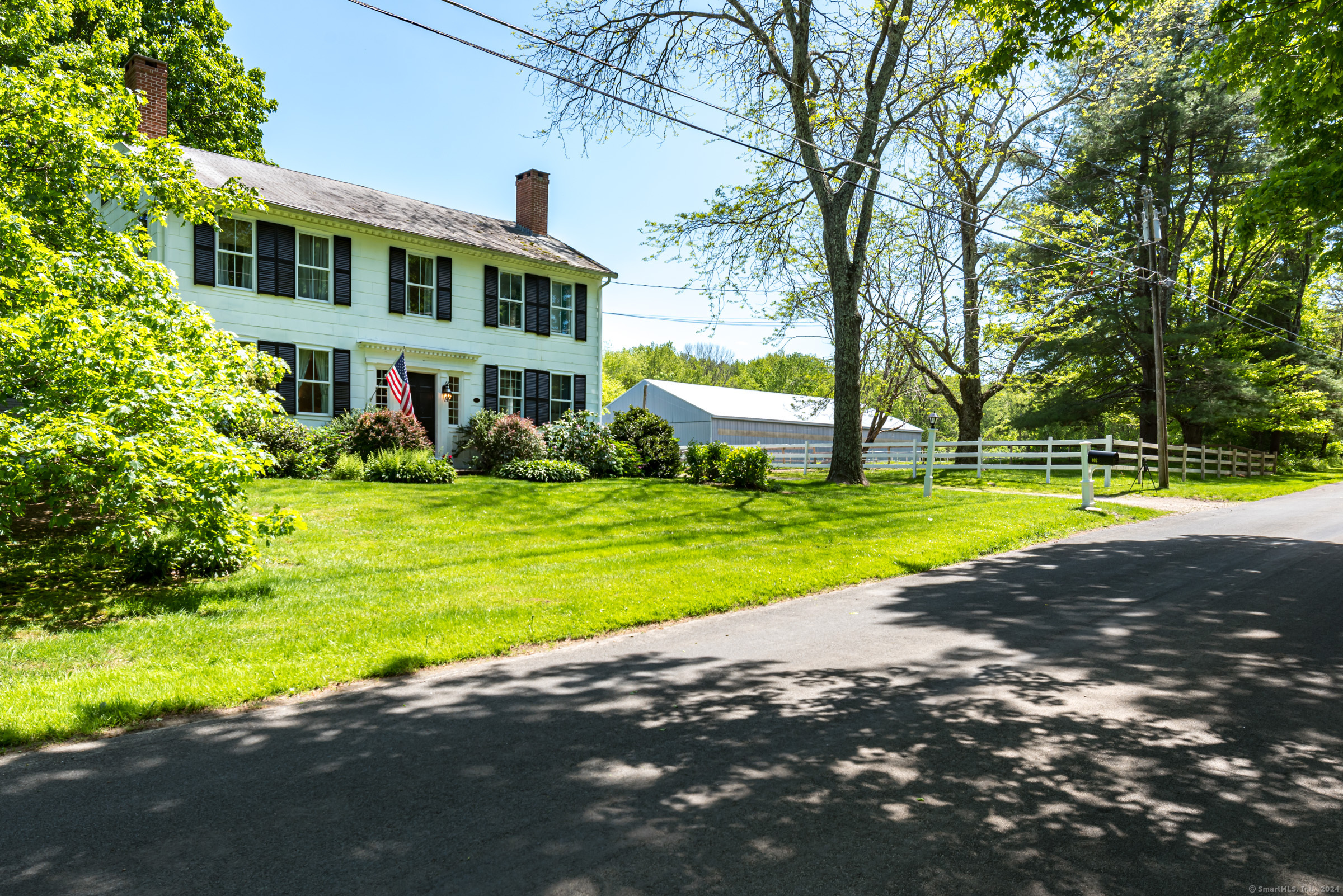 a view of a house with a big yard and large trees