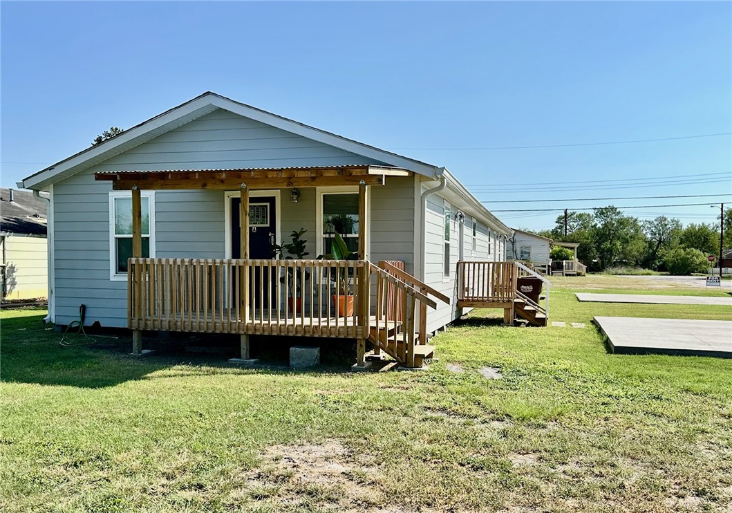 a view of a house with a yard and deck