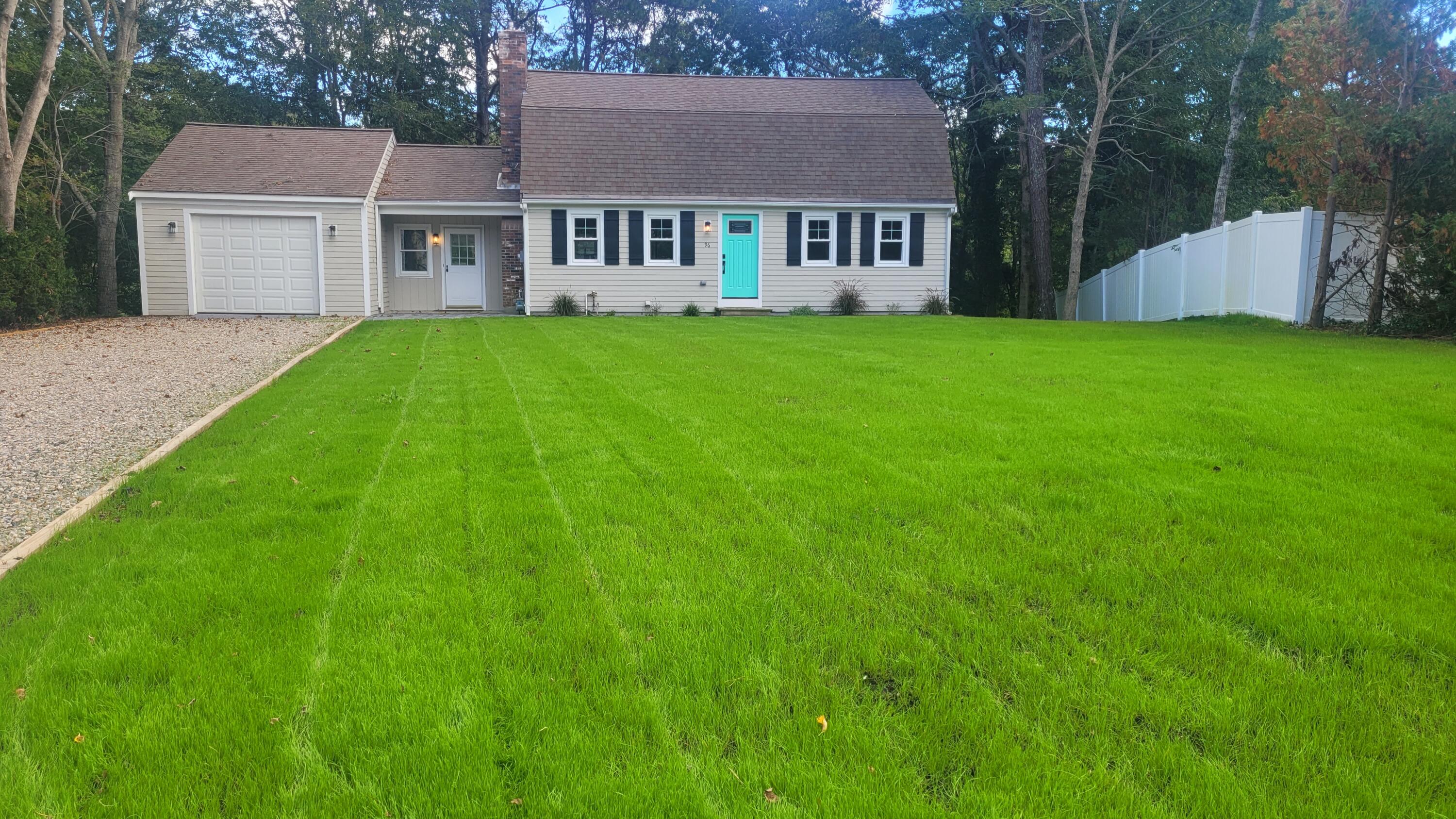 a view of a house with a big yard and large trees