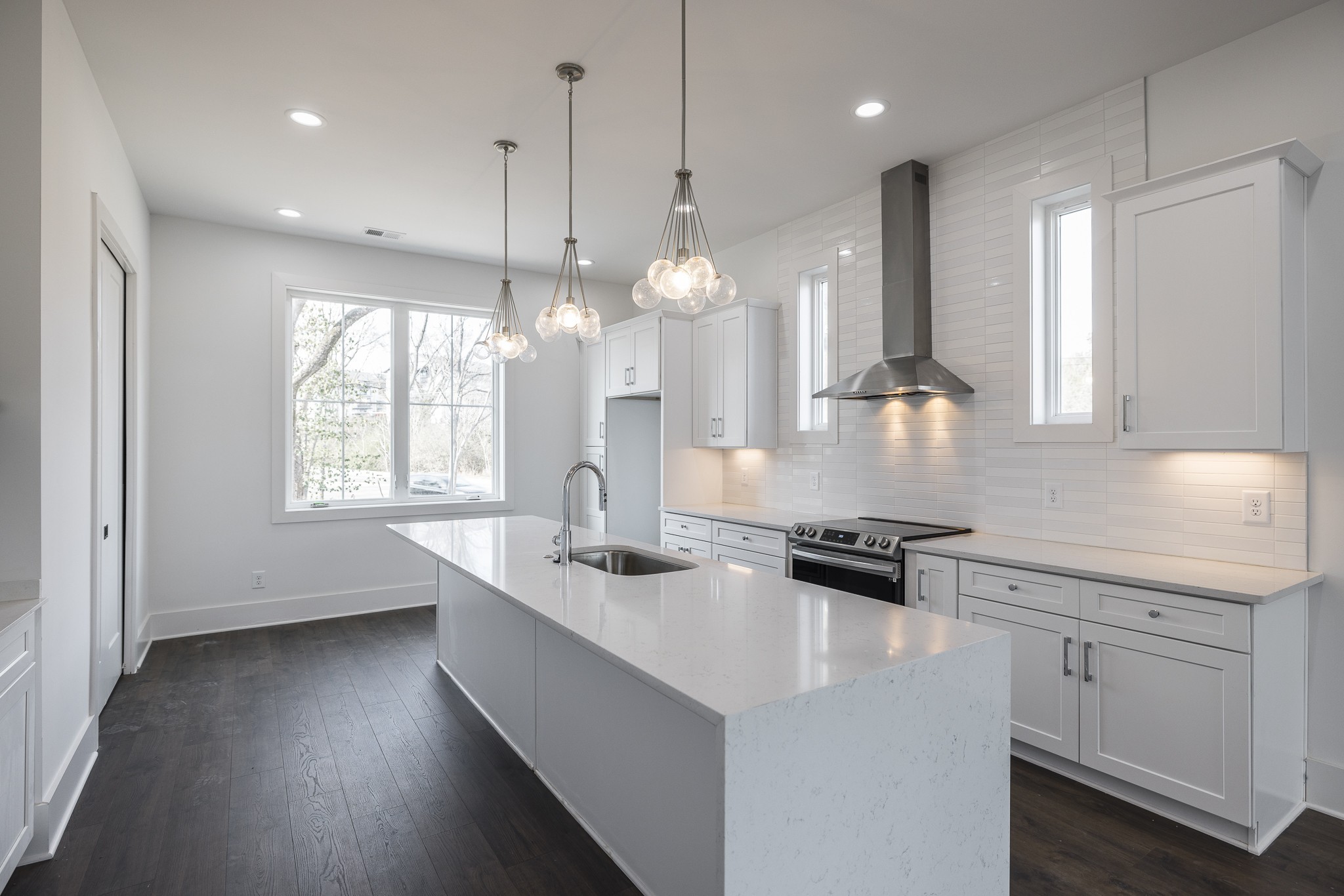 a kitchen with kitchen island granite countertop a sink a counter space appliances and a window