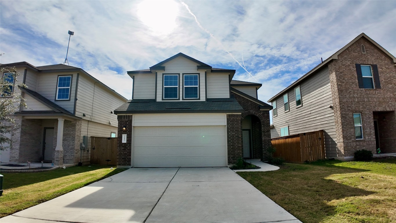 a front view of a house with a yard and garage