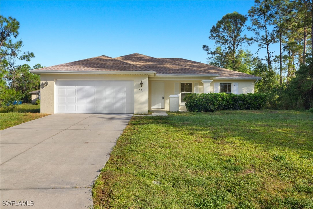 a front view of a house with a yard and garage